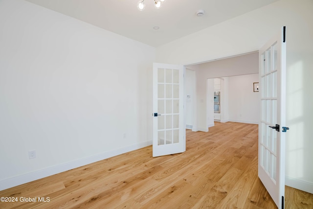 unfurnished room with french doors and wood-type flooring