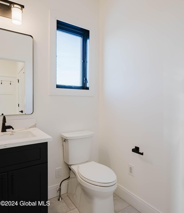 bathroom with tile patterned flooring, vanity, and toilet