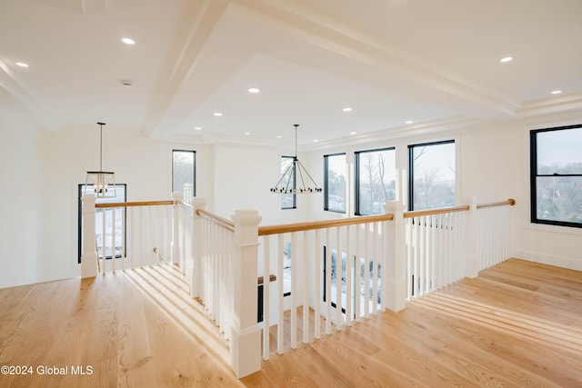 corridor with beam ceiling, light hardwood / wood-style flooring, and an inviting chandelier