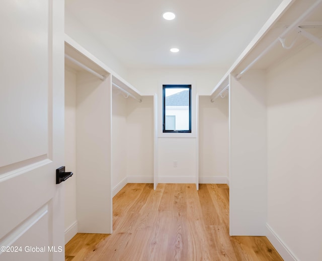 walk in closet with light hardwood / wood-style floors