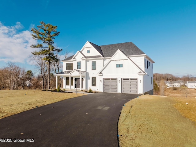 view of front of property featuring a porch, a garage, and a front yard