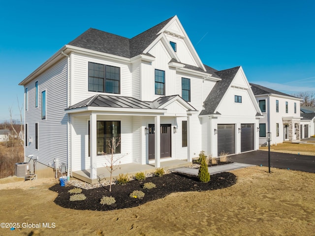 view of front of home featuring a garage, covered porch, and cooling unit