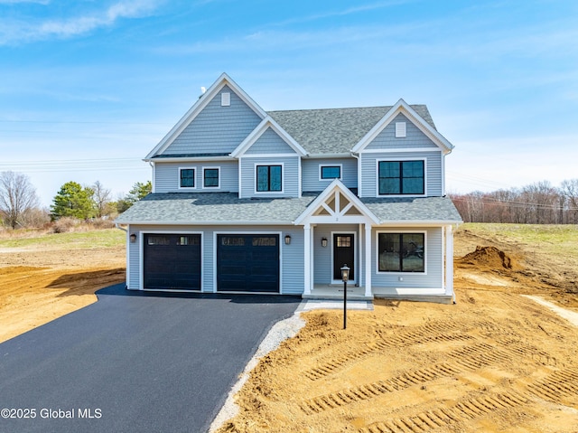 view of front of property with a garage, roof with shingles, and aphalt driveway