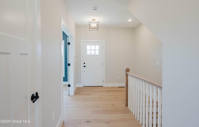 entryway with recessed lighting, baseboards, an inviting chandelier, and light wood-style flooring