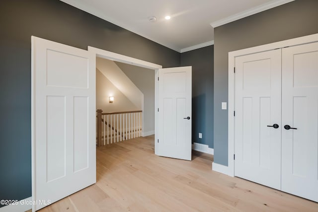 additional living space featuring baseboards and light wood-type flooring
