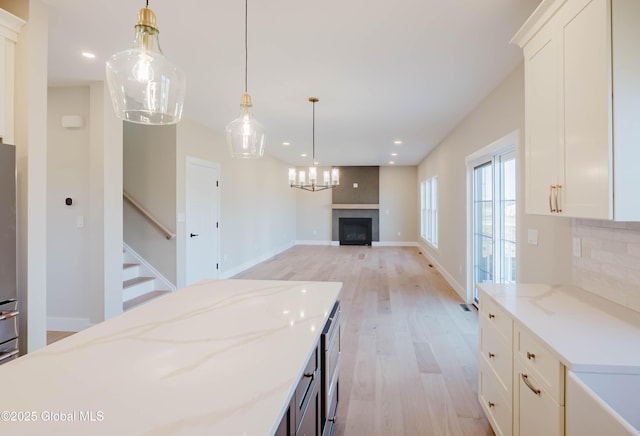 kitchen with light wood-style flooring, a fireplace, white cabinets, backsplash, and recessed lighting