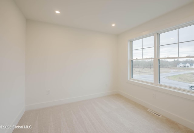 empty room featuring baseboards, visible vents, recessed lighting, and light colored carpet