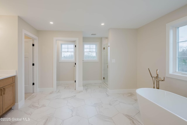 bathroom featuring a shower stall, a freestanding tub, vanity, and recessed lighting