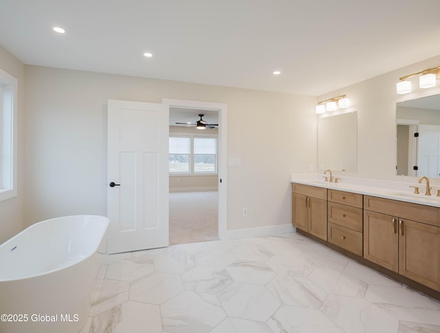 full bathroom with a sink, double vanity, a freestanding bath, marble finish floor, and ceiling fan