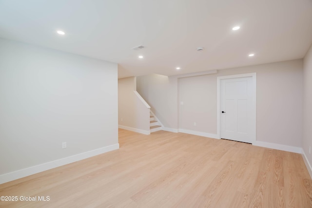 finished below grade area featuring stairs, light wood-type flooring, baseboards, visible vents, and recessed lighting