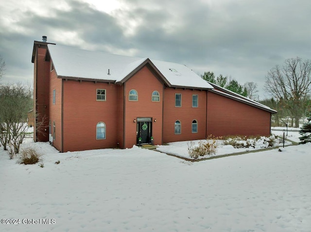 view of snow covered rear of property