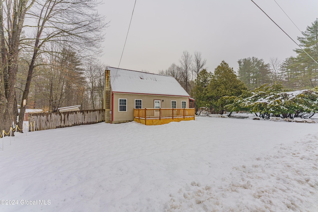 snow covered rear of property featuring a deck