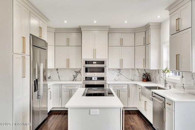 kitchen featuring dark hardwood / wood-style floors, a center island, appliances with stainless steel finishes, and tasteful backsplash