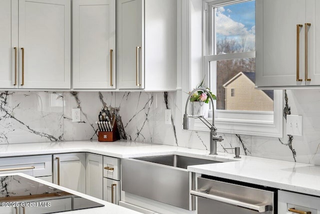 kitchen featuring sink, tasteful backsplash, stainless steel dishwasher, and light stone counters