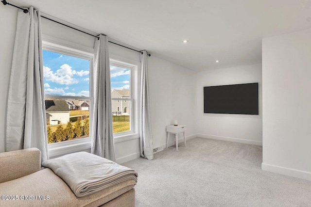 sitting room featuring light colored carpet and a healthy amount of sunlight