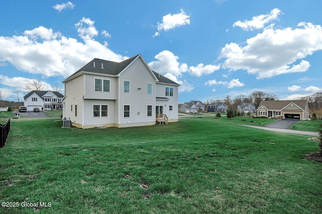 rear view of property with a yard and central AC