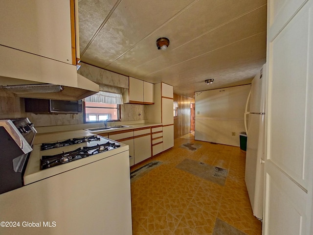 kitchen featuring white appliances, sink, and extractor fan