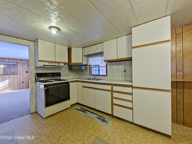 kitchen with backsplash, a textured ceiling, white range, sink, and white cabinetry