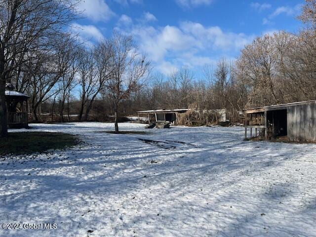 yard layered in snow with an outdoor structure