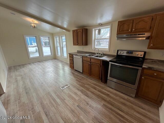 kitchen with lofted ceiling, sink, light hardwood / wood-style flooring, stainless steel appliances, and a chandelier