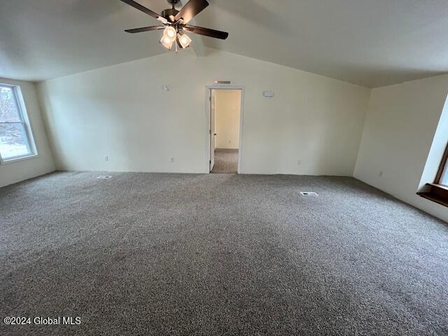 spare room featuring carpet flooring, ceiling fan, and lofted ceiling