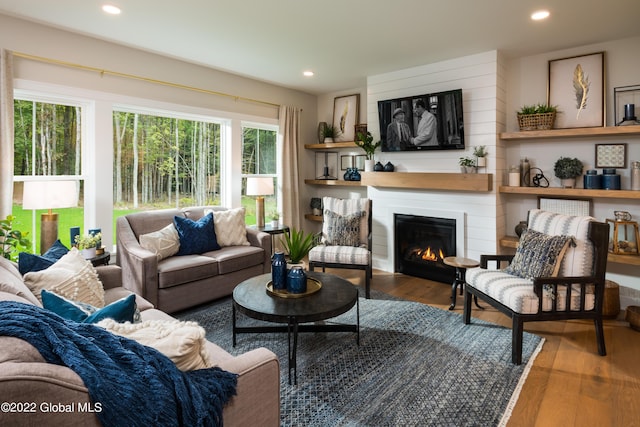 living room with recessed lighting, a large fireplace, and wood finished floors