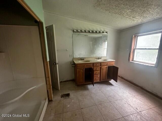 bathroom featuring tile patterned flooring, vanity, and a textured ceiling