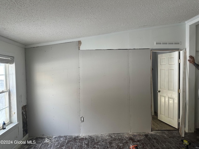 unfurnished bedroom featuring lofted ceiling, a textured ceiling, and multiple windows