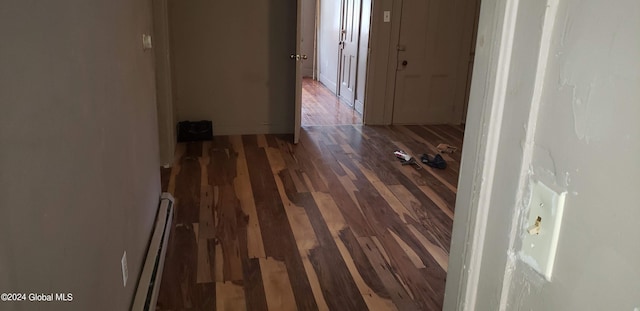 hallway with dark wood-type flooring and a baseboard heating unit