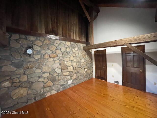 bonus room featuring hardwood / wood-style floors and beam ceiling