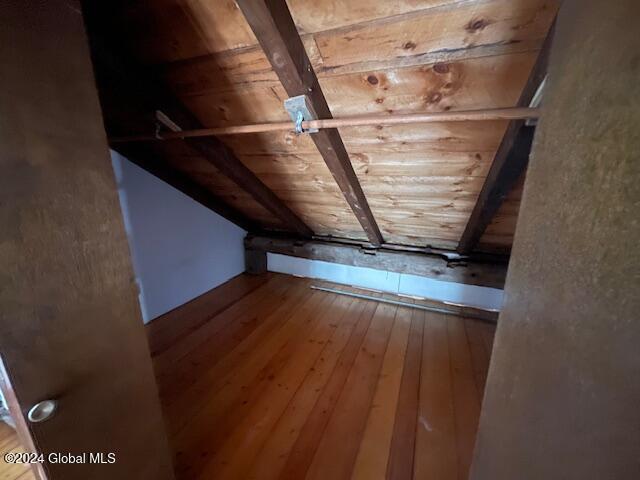 additional living space featuring beam ceiling, hardwood / wood-style floors, and wooden ceiling