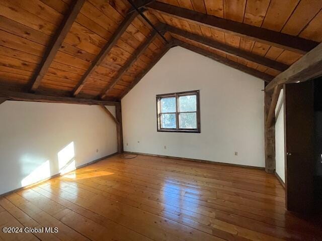 additional living space with hardwood / wood-style flooring, vaulted ceiling with beams, and wooden ceiling