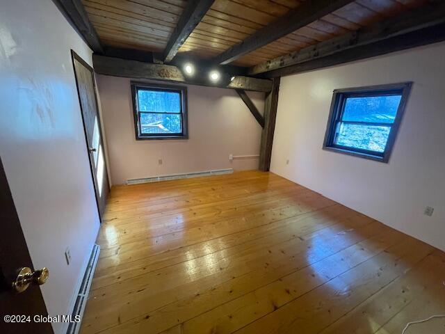 basement featuring light hardwood / wood-style floors, a baseboard heating unit, and wood ceiling