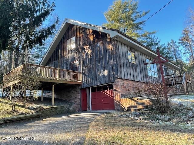 view of home's exterior featuring a garage and a wooden deck