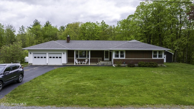 single story home featuring covered porch, a garage, and a front lawn