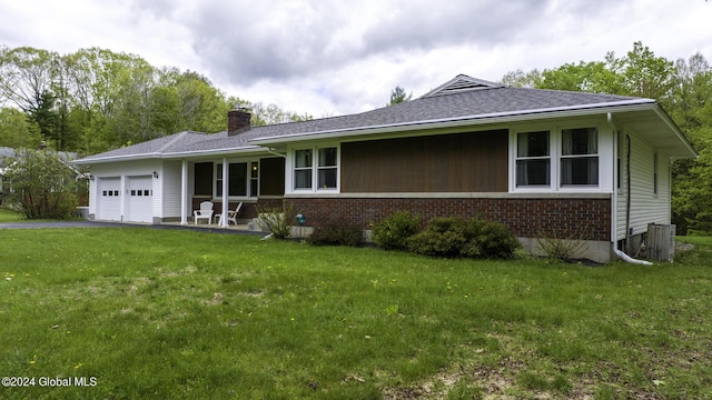 single story home featuring a garage and a front lawn