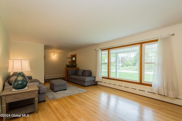 living room featuring hardwood / wood-style flooring, a healthy amount of sunlight, and baseboard heating