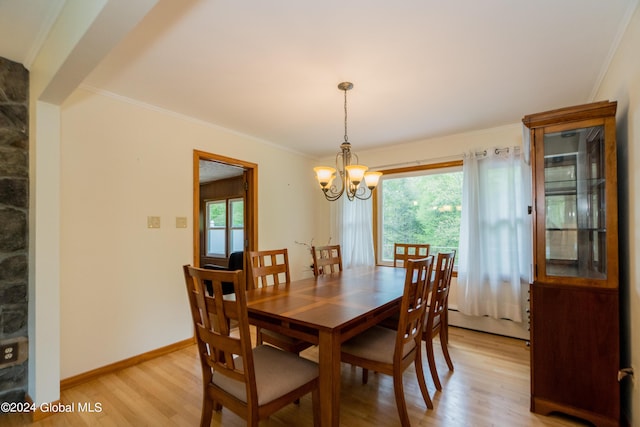 dining room featuring crown molding, light hardwood / wood-style floors, a baseboard radiator, and an inviting chandelier