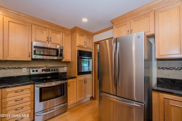 kitchen featuring tasteful backsplash, dark stone countertops, and stainless steel appliances