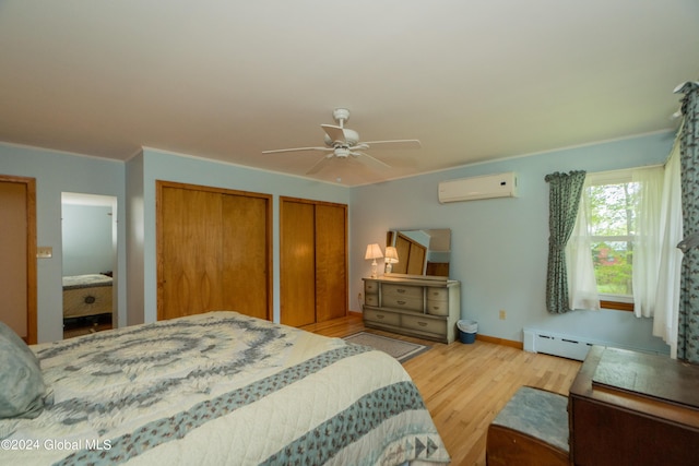 bedroom featuring ornamental molding, a wall mounted AC, ceiling fan, light hardwood / wood-style floors, and multiple closets