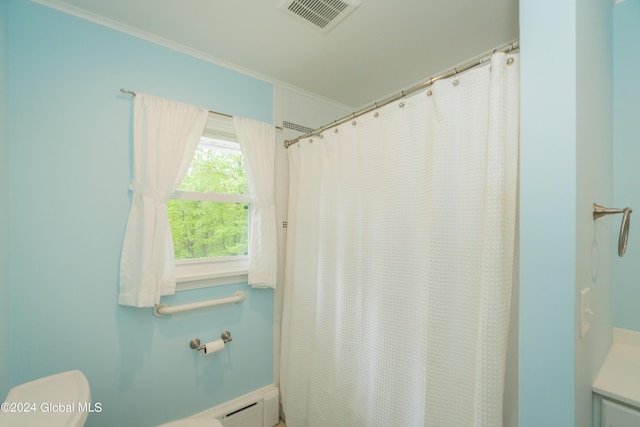 bathroom with a shower with curtain, crown molding, a baseboard heating unit, and toilet