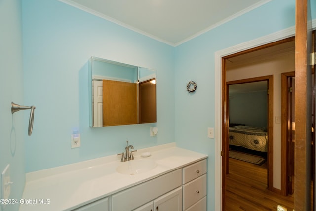 bathroom featuring crown molding, hardwood / wood-style floors, and vanity