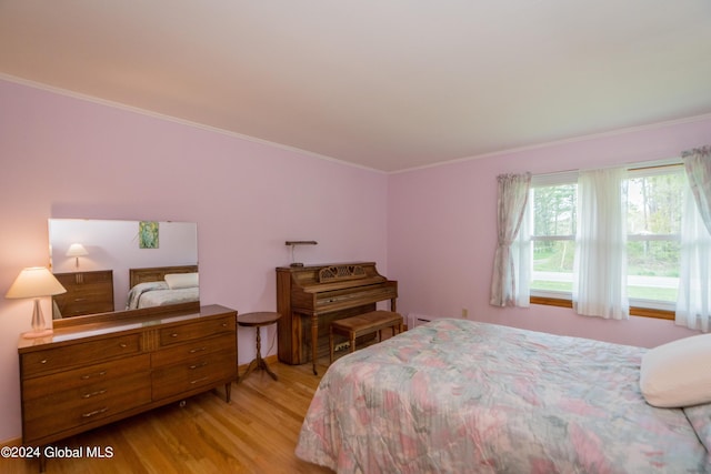 bedroom featuring light wood-type flooring and ornamental molding