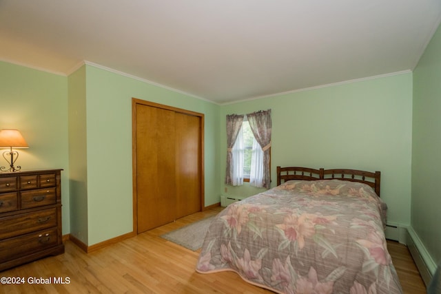 bedroom featuring light wood-type flooring, a baseboard radiator, a closet, and ornamental molding