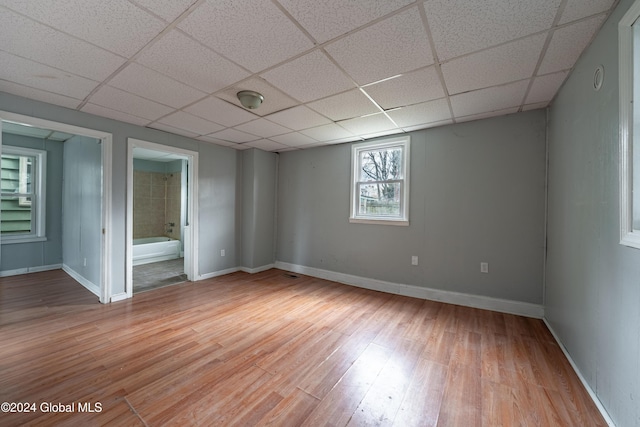 empty room with a paneled ceiling and light hardwood / wood-style floors