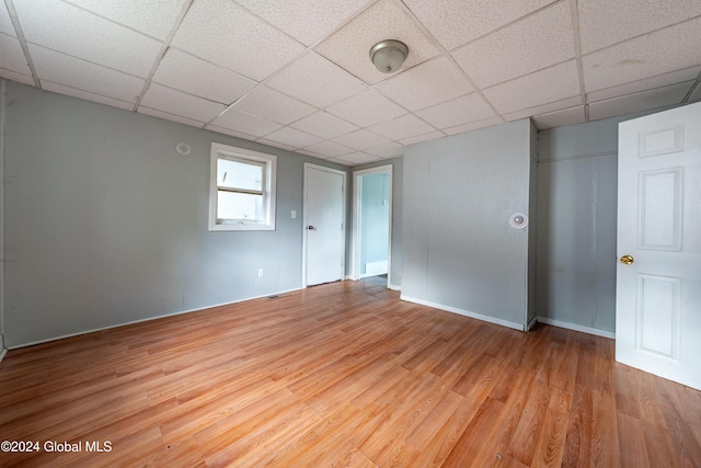 unfurnished room featuring a paneled ceiling and light wood-type flooring