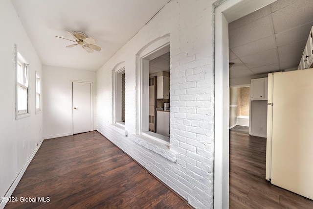 hall featuring a drop ceiling and dark hardwood / wood-style floors