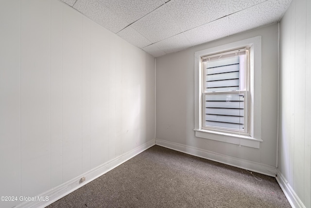 spare room featuring carpet flooring and a paneled ceiling