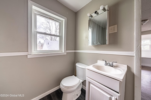 bathroom featuring hardwood / wood-style floors, vanity, a healthy amount of sunlight, and toilet