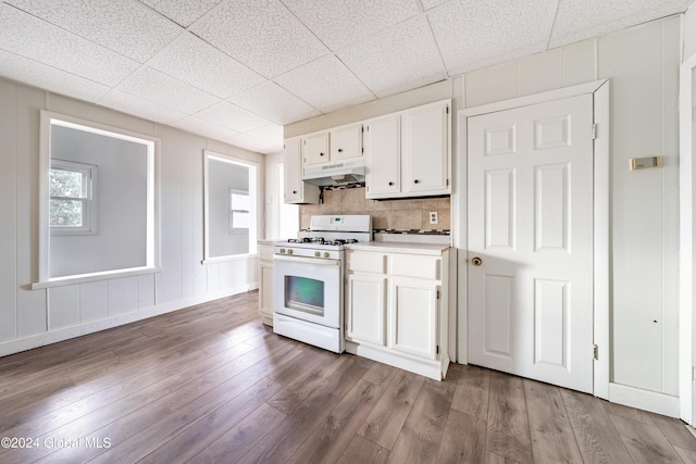 kitchen with backsplash, white gas range, white cabinets, and light wood-type flooring